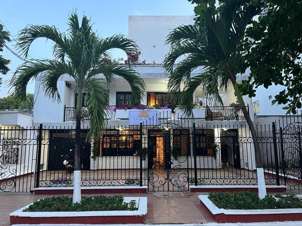 卡塔赫纳Hostal Boutique Casa Pere的建筑前方有两棵棕榈树的铁艺围栏