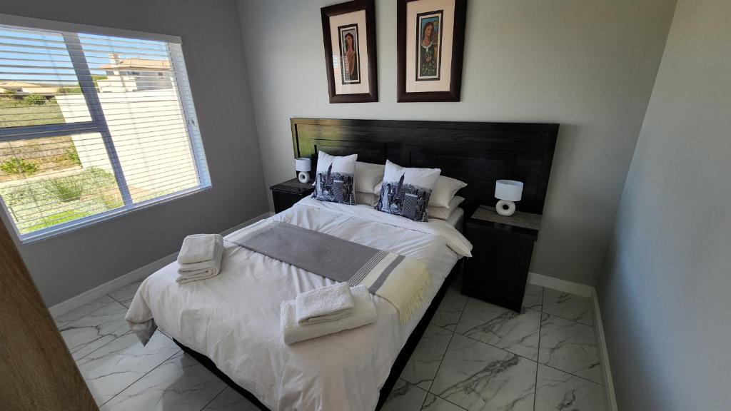 兰格班One Bedroom Unit with Kitchenette in Langebaan Country Estate - Solar Power的卧室配有一张带白色床单和枕头的大床。