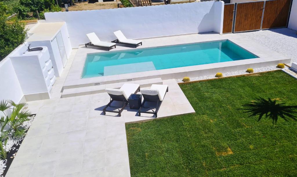 扎霍拉Villa Turquesa的后院设有带椅子的游泳池和草坪