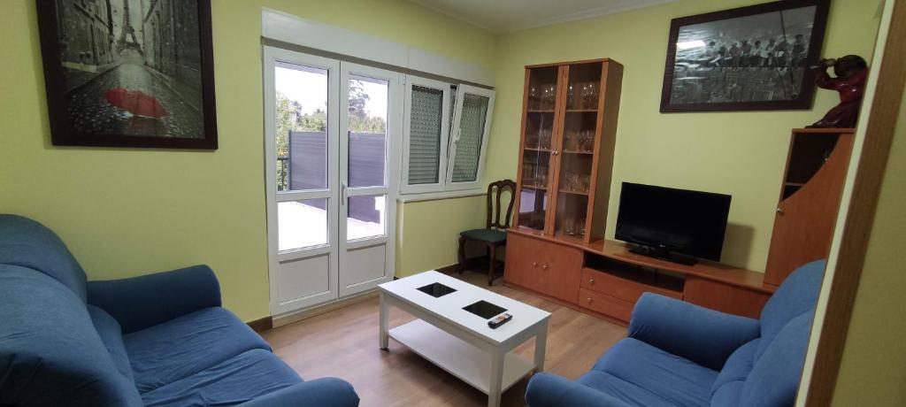 巴雷罗斯Bruma的客厅配有2张蓝色沙发和电视