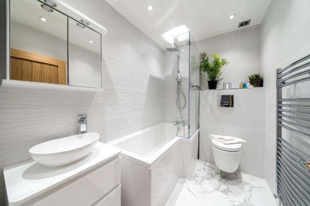 Forest HillStunning 2 Bed 2 Bath Luxury London Apartment!的白色的浴室设有水槽和卫生间。