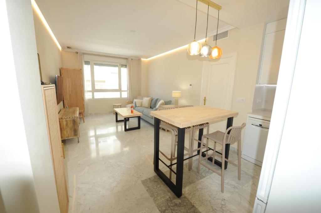 加的斯Apartamento reformado con vistas al mar的厨房以及带桌子和沙发的客厅。