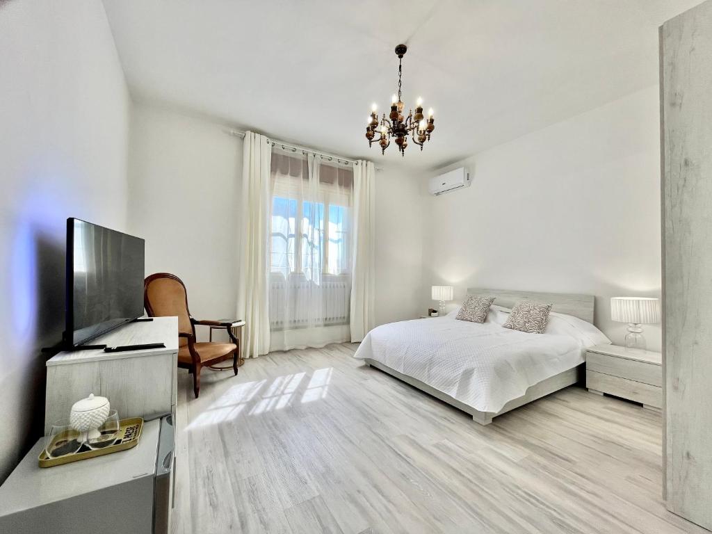 MesolaLa Villetta nel Delta的白色卧室配有床和平面电视