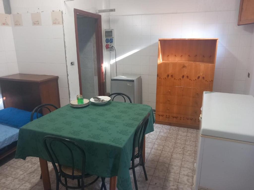 appartamento di Domenico的客房设有带椅子的绿色桌子和冰箱。