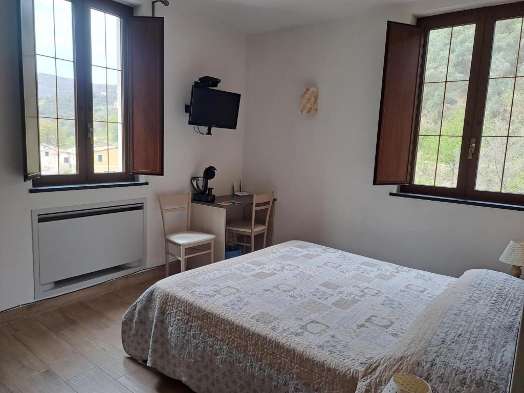 莱万托Agriturismo A' Taversa的卧室配有一张床、一张书桌和窗户。