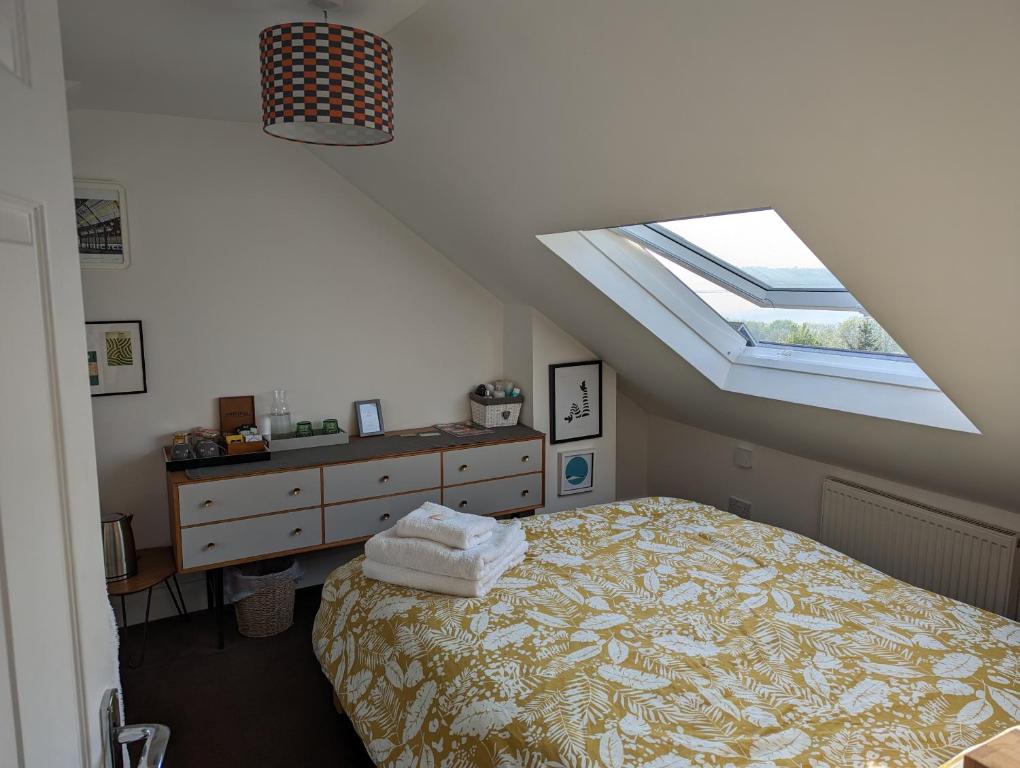 布莱顿霍夫South Downs View的阁楼卧室配有床和天窗