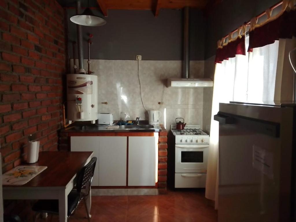 埃斯克尔Departamentos alvear的厨房配有白色炉灶和桌子
