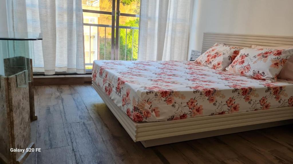 里约热内卢Apartamento Sandy-Zona Sul的一间卧室配有一张带花卉床罩的床