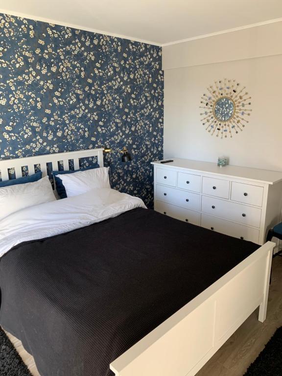 里摩日Chambre complètement indépendante !的一间卧室配有一张床和一张带花卉壁纸的墙壁