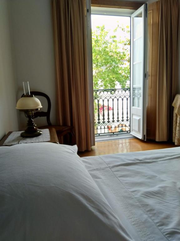 阿托吉亚达巴莱亚CASA DO LARGO的一间卧室设有一张床,并有通往阳台的门
