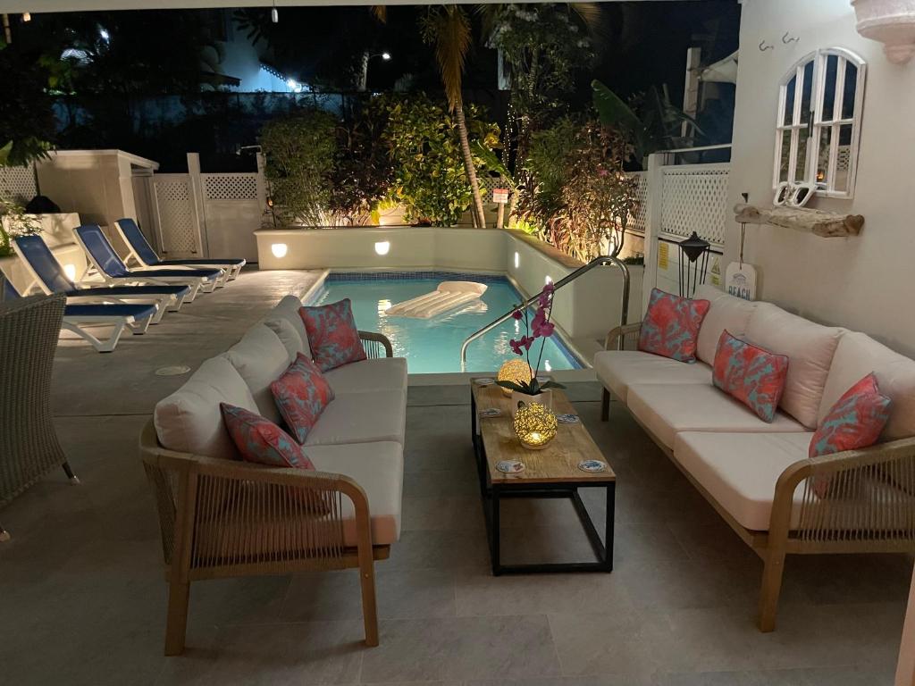 圣詹姆斯Nanpa, Luxury Family Three Bed Villa, St James West coast, Private pool的一个带沙发和椅子的庭院和一个游泳池