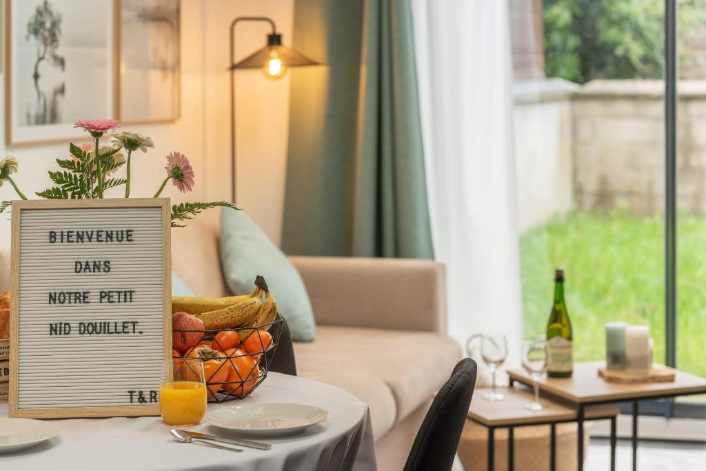 鲁昂Le Nid Douillet : Superbe Appartement + Jardin privatif的一张桌子,上面有标牌,上面有一篮水果