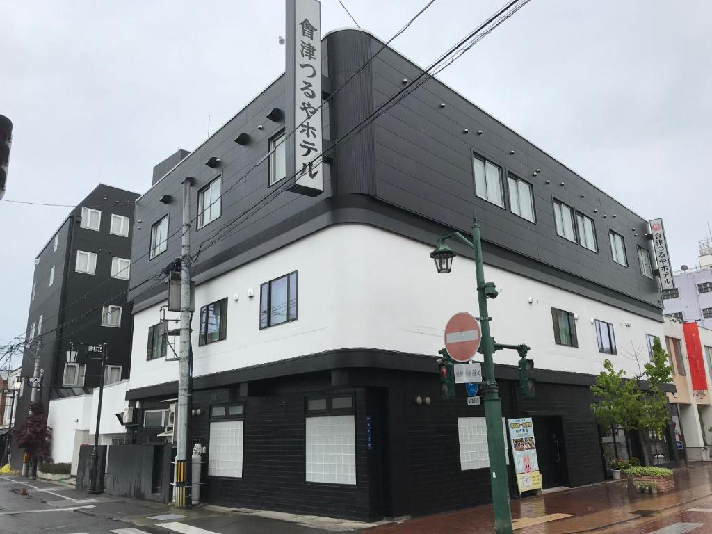 会津若松Aizu Tsuruya Hotel的街道拐角处的黑白建筑