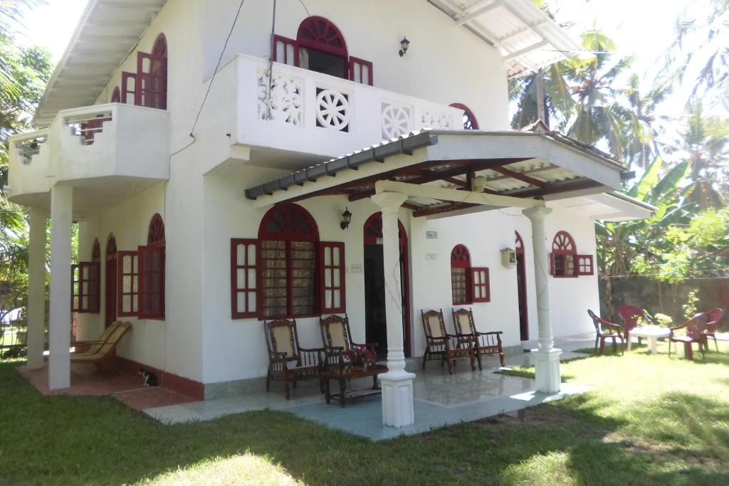 希克杜沃Raj Villa Kumarakanda Hikkaduwa的带阳台和椅子的庭院