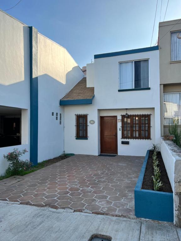 恩塞纳达港Casa Mediterraneo的白色和蓝色的房子,有车道