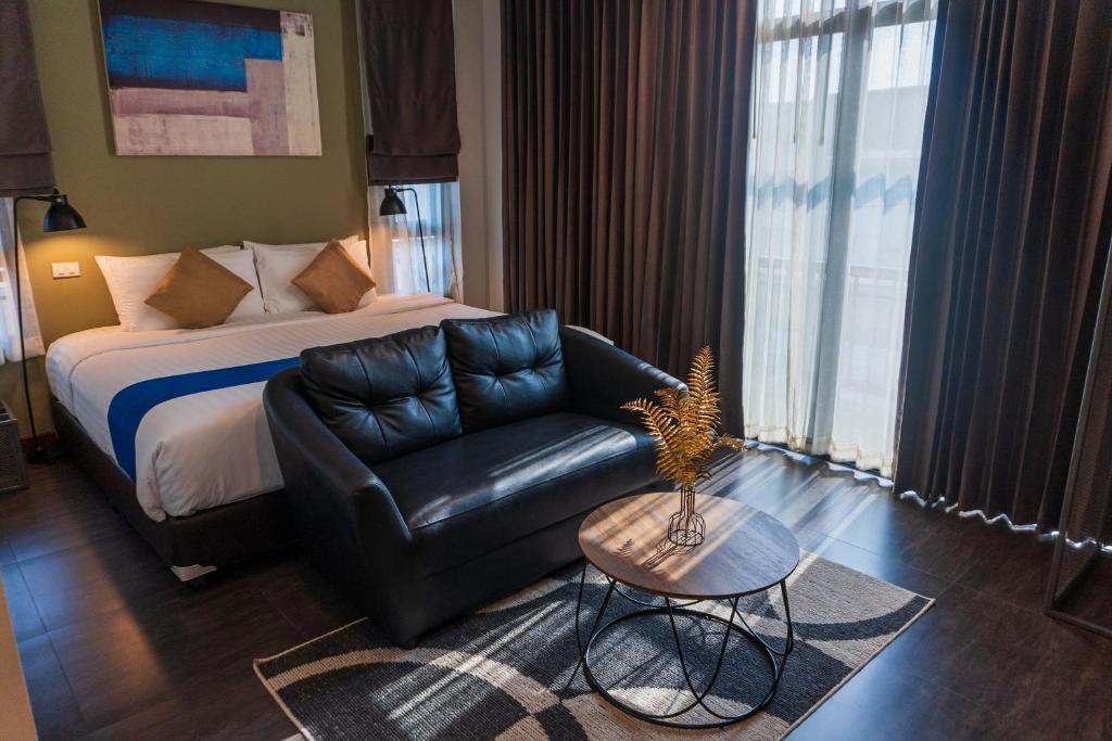 清迈财富精品清迈酒店的酒店客房配有床、沙发和桌子。