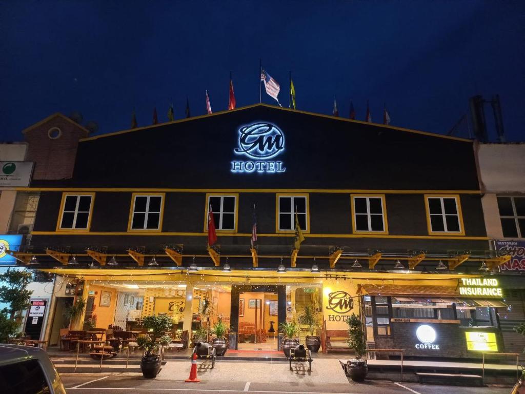 樟仑GM酒店的一家在晚上在前面有标志的酒店