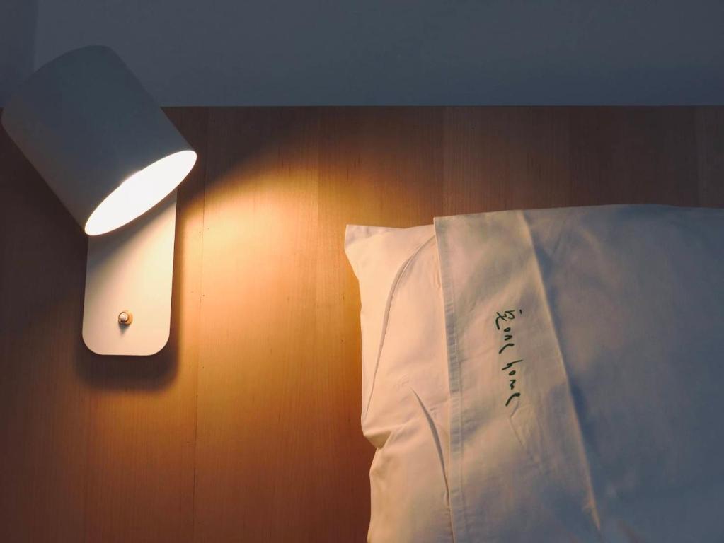 车城垦丁一宅的一张带白色枕头的床和墙上的灯