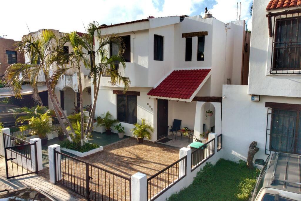 坎昆Cómoda casa céntrica con alberca privada en Cancún的白色的房子,有围栏和棕榈树