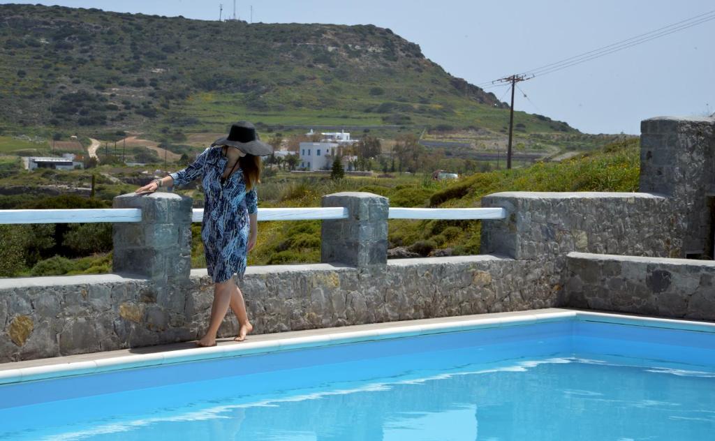 阿波罗尼亚Glaronisia Hotel的站在游泳池旁的女人