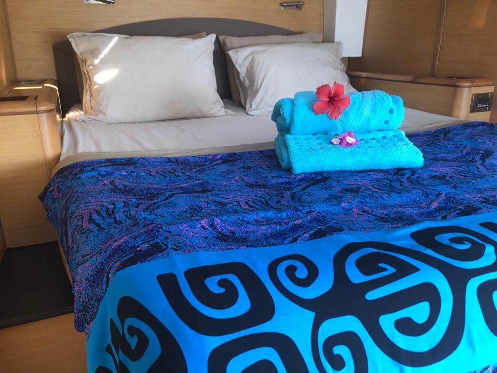 乌图罗阿Catamaran Apetahi的床上有两条蓝色的毛巾