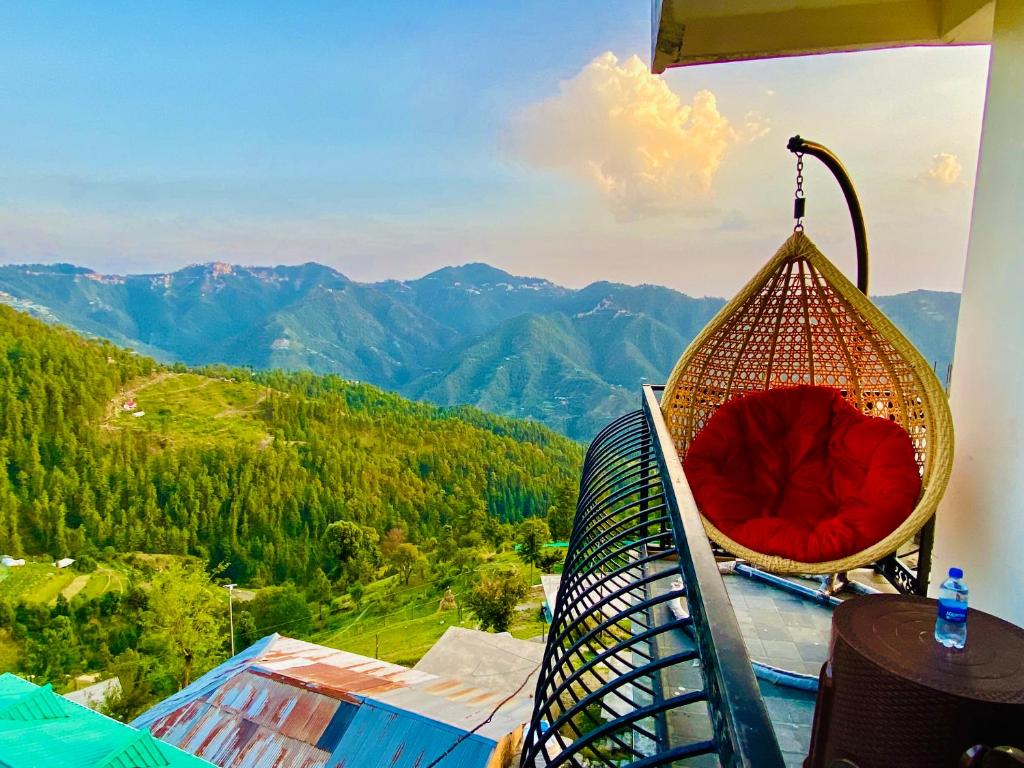 西姆拉Staynest Mashobra with balcony- A peacefull stay的山景阳台上的椅子
