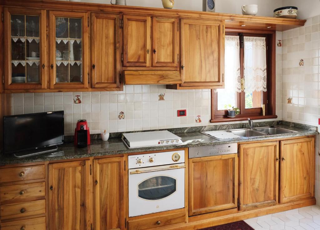 奥斯塔Rose Apartment的厨房配有木制橱柜、水槽和炉灶。