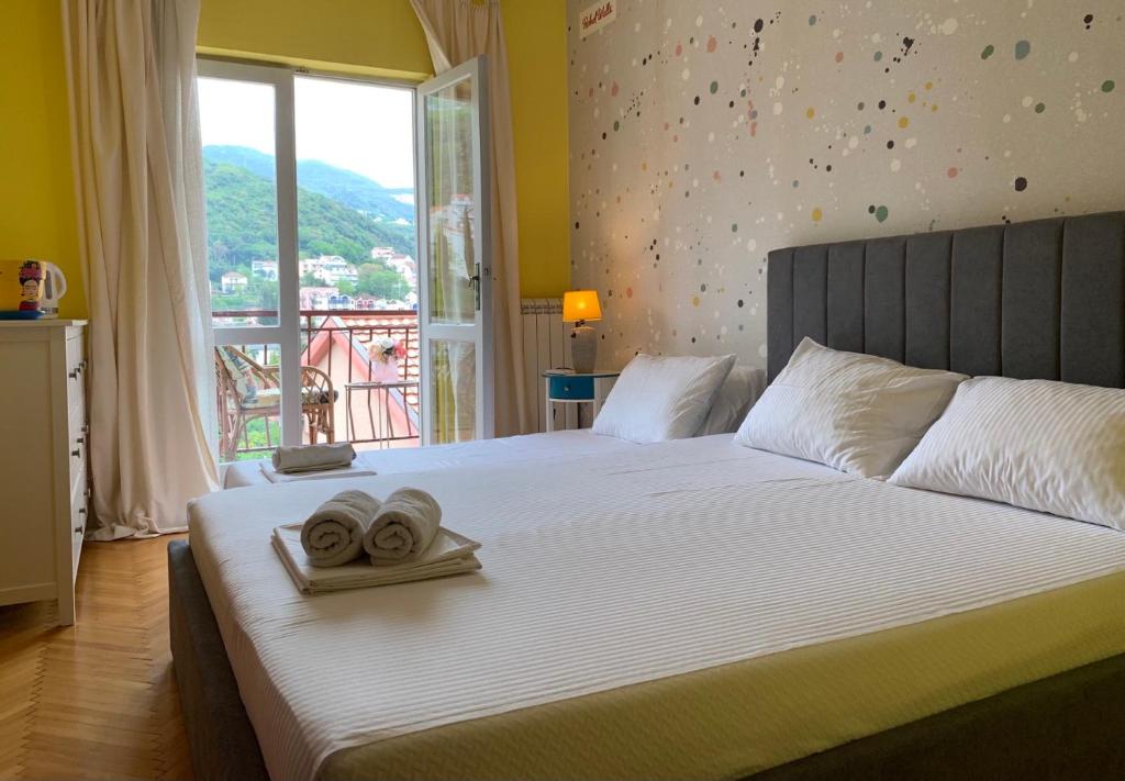 伊加洛Apartmani SRNA, Igalo的一间卧室配有一张床,上面有两条毛巾