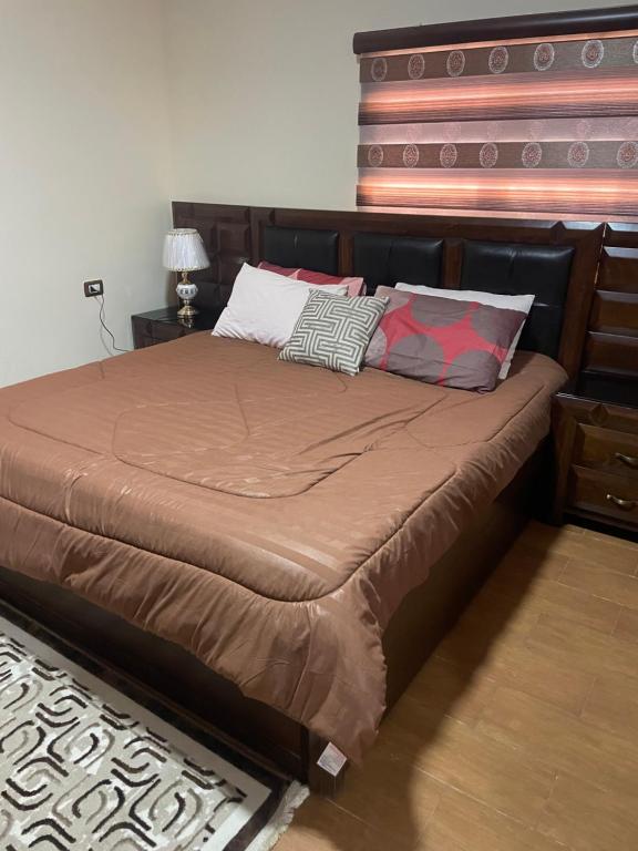 Ad Dimnahمزرعة النجم Najem farm的卧室内的一张带枕头的床