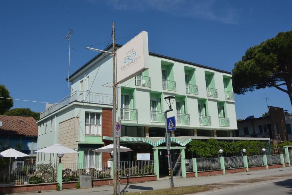 马里纳－迪拉文纳Hotel Maddalena的一座绿色的白色建筑,前面有标志