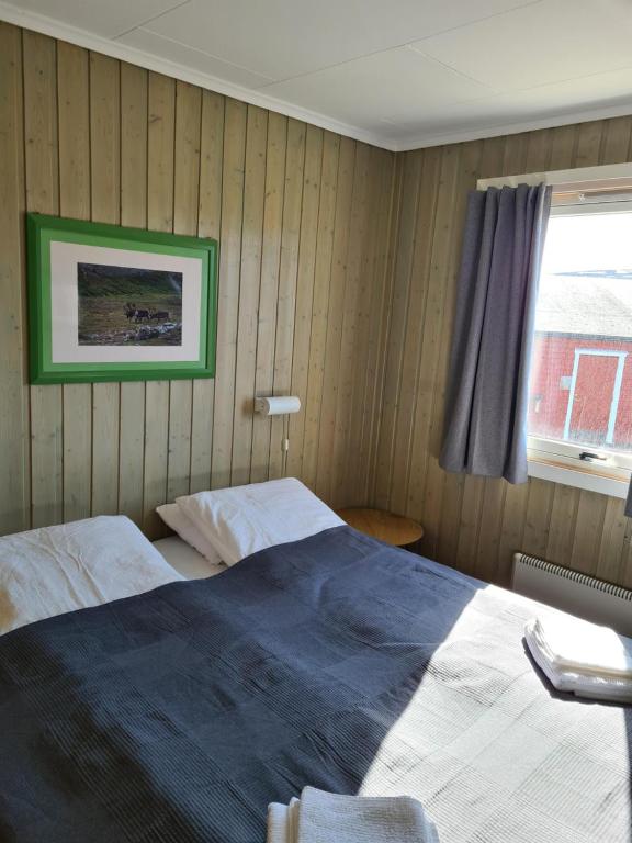 贝勒沃格Berlevåg Motell AS的一间卧室设有一张床和一个窗口