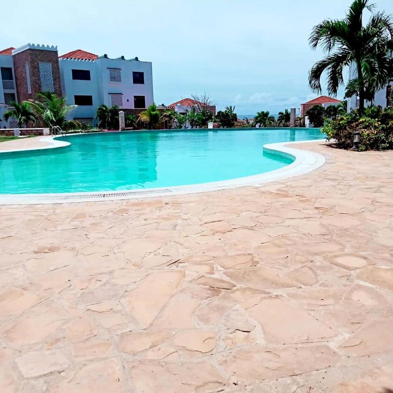 KikambalaLux Suites 3 Bedroom Sultan Palace Town House的蓝色海水度假村的游泳池