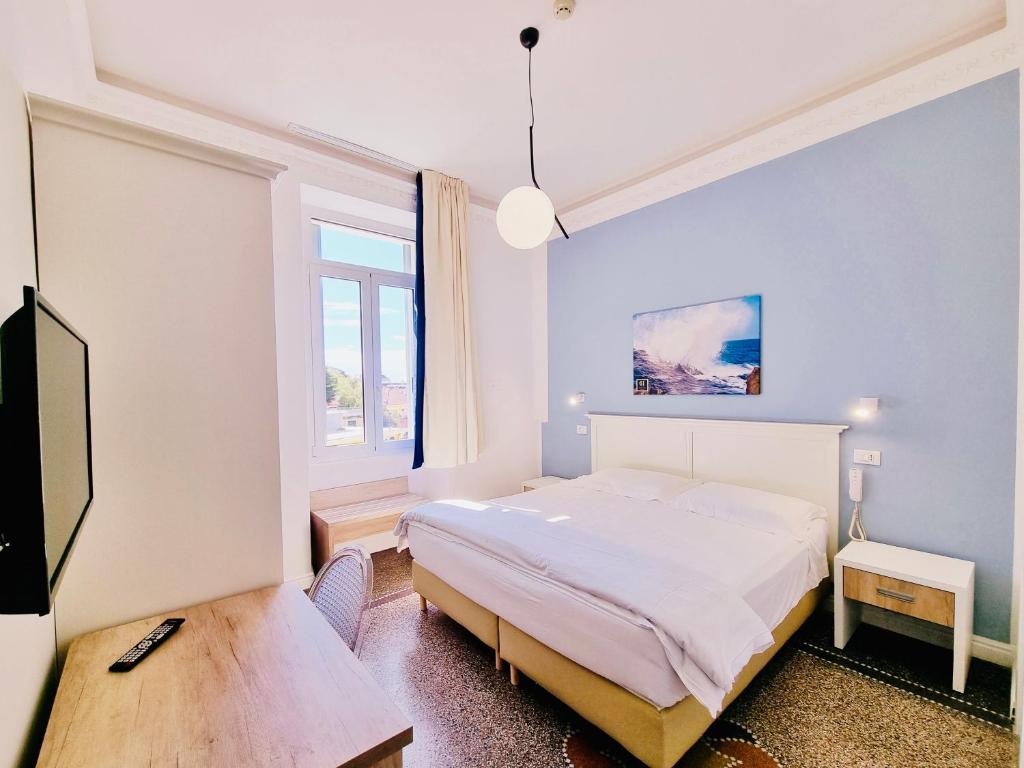 拉帕洛Hotel Canali, Portofino Coast的一间卧室配有一张床、一张书桌和一个窗户。