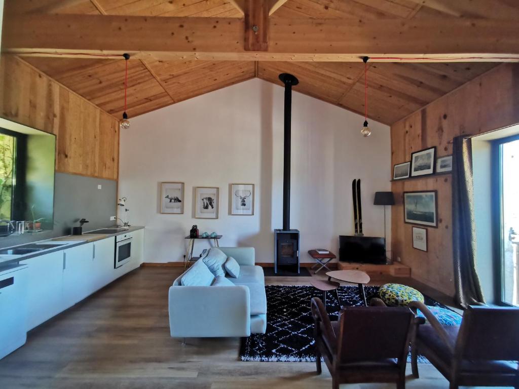HauxGîte de charme au cœur de l'entre-deux-mers的客厅设有白色沙发和木制天花板。
