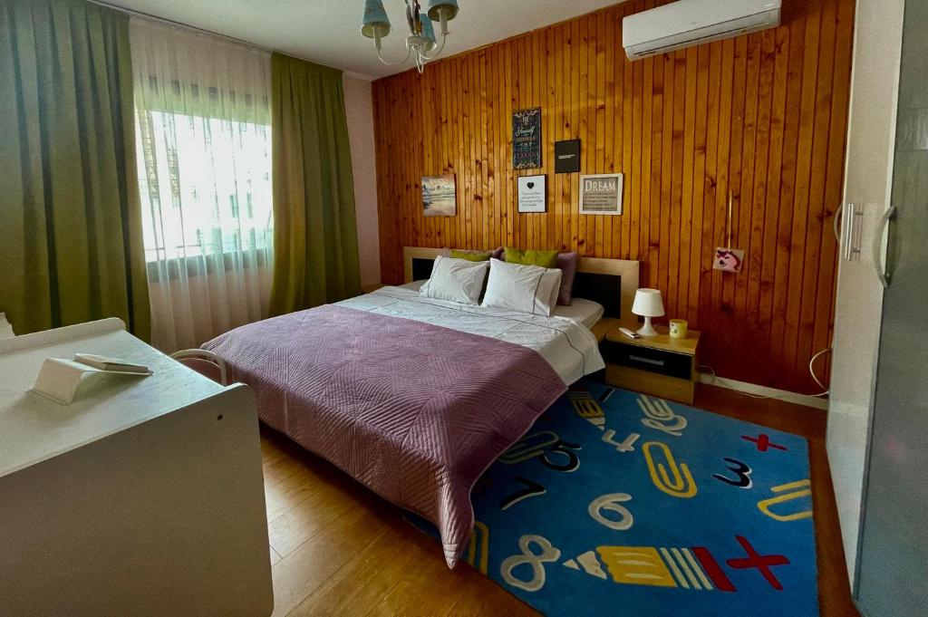 普里什蒂纳Villa Garden的一间卧室配有一张蓝色地毯的床