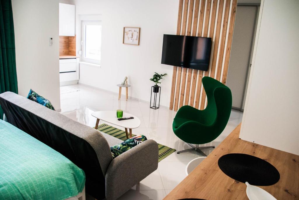 萨格勒布Apartments Lisinski - Private parking的带沙发和绿色椅子的客厅