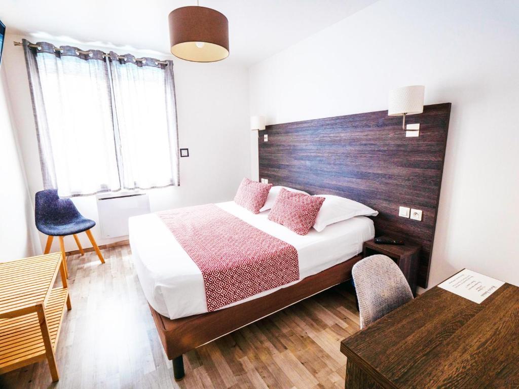 博韦大教堂酒店的一间卧室配有一张床和一个木制床头板