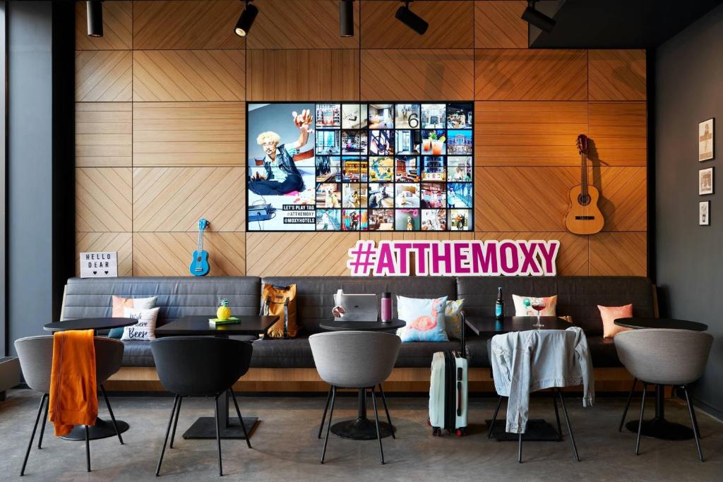 爱丁堡Moxy Edinburgh Fountainbridge的一间配有沙发和墙上电视的餐厅