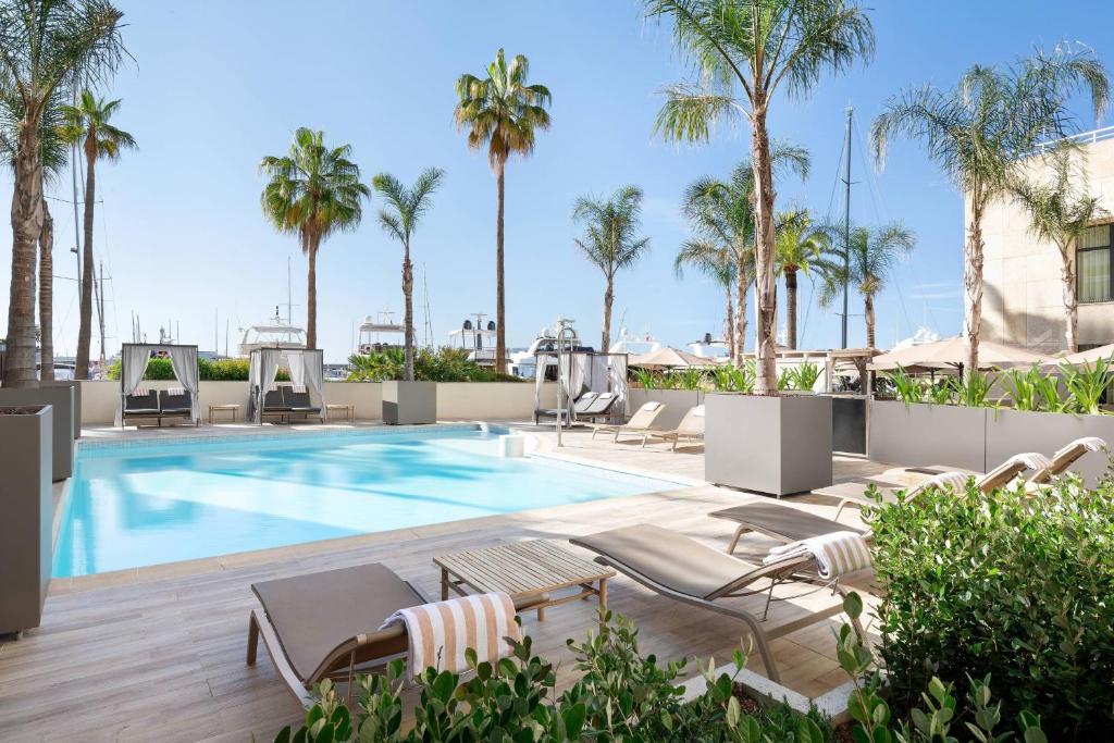 卡普戴尔万豪摩纳哥门度假酒店的一个带躺椅和棕榈树的游泳池