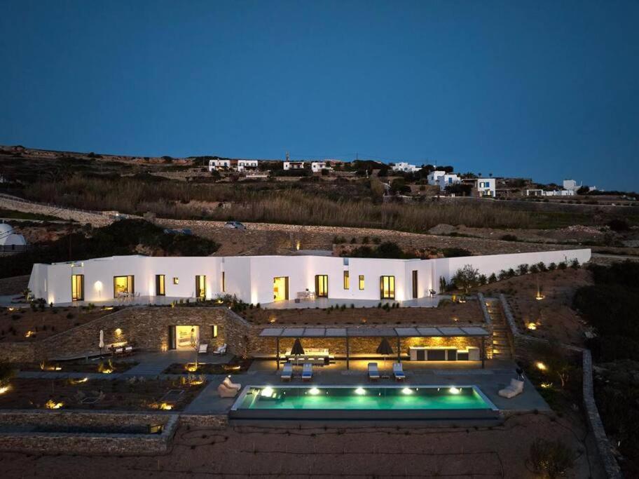 KrotiriOlithos Villas的一座在晚上设有游泳池的大房子