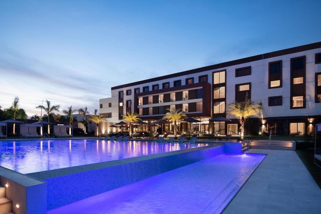 蓬塔卡纳AC Hotel by Marriott Punta Cana的一座游泳池,在晚上在建筑物前