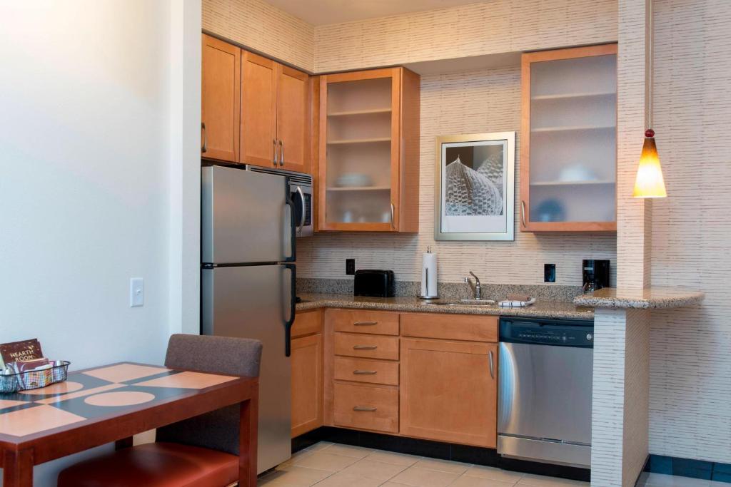 莫林莫林四城原住客栈的厨房配有木制橱柜和不锈钢冰箱。