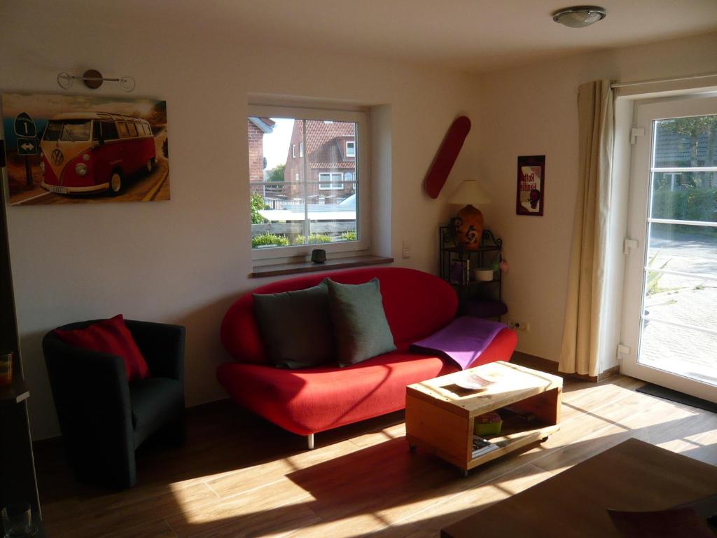 Neue Tiefe FehmarnAloha 2的客厅设有红色的沙发和窗户。