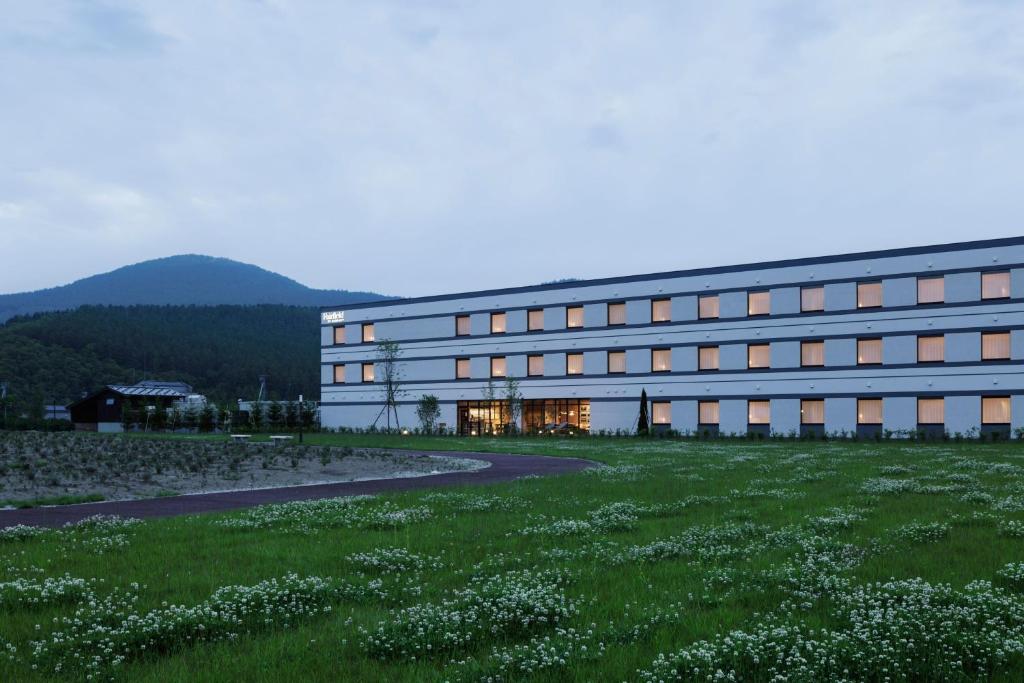 南富良野Fairfield by Marriott Hokkaido Minamifurano的前面有草地的建筑