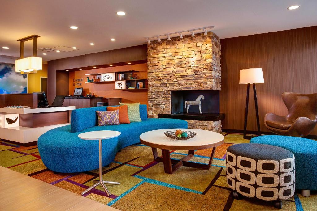 林垦林肯市东南万豪费尔菲尔德酒店的客厅配有蓝色的家具和壁炉