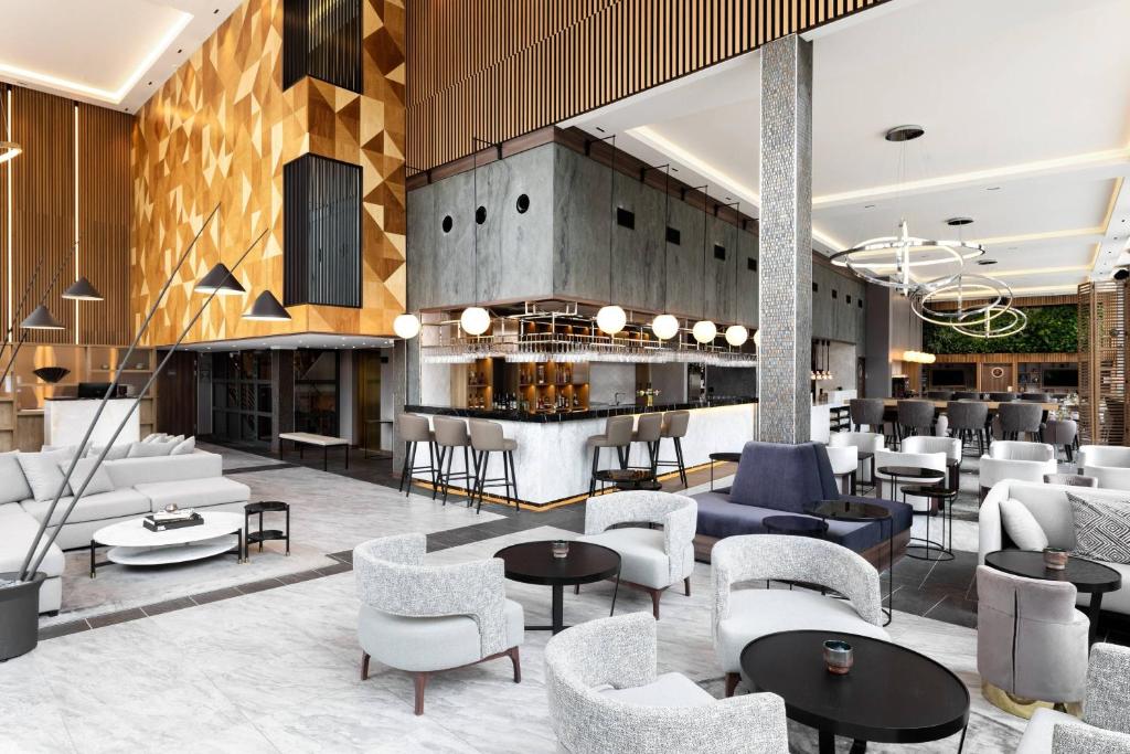 索尔纳AC Hotel by Marriott Stockholm Ulriksdal的大堂设有桌椅和酒吧。