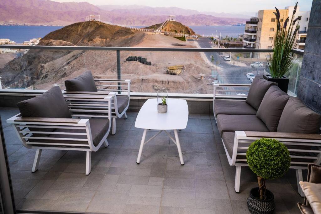 埃拉特Sea View Boutique Apartment的阳台配有沙发、椅子和桌子