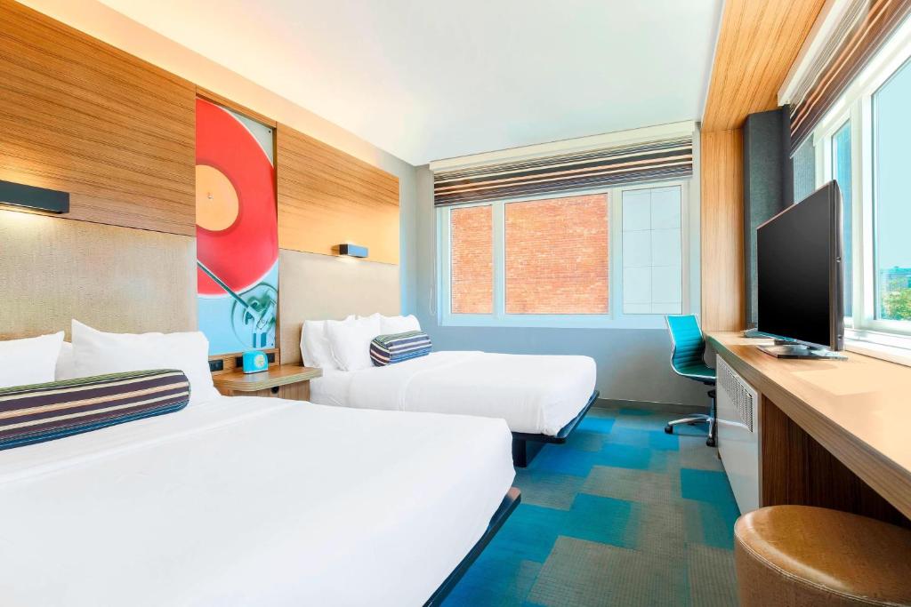 纽约哈莱姆雅乐轩酒店的酒店客房设有两张床和一台平面电视。