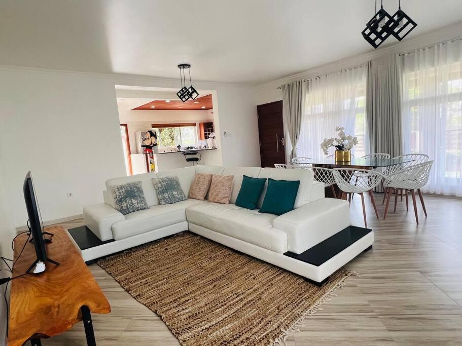 普拉伊拉多比莱尼Casa Conforto Bilene的客厅配有白色的沙发和桌子