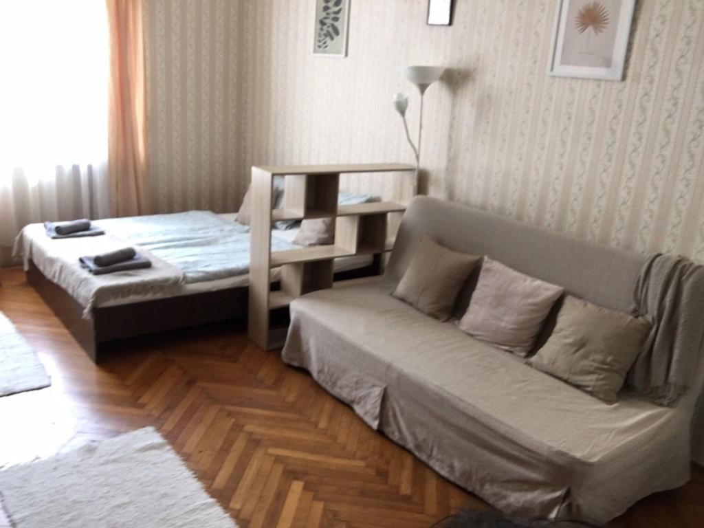 布达佩斯Cozy flat at Stadionok M station的一间设有两张床和一张沙发的房间